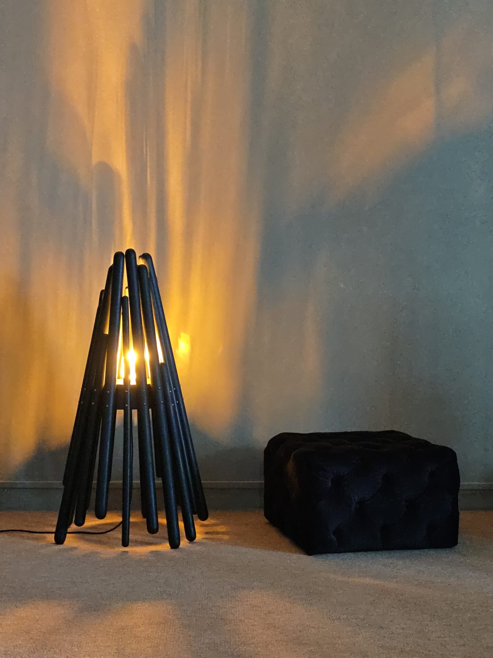 An atmosphere scene featuring the Blaze floor lamp by FLOWLIGHT DESIGN INC. This artistic, handmade floor lamp is crafted from natural solid wood, embodying a European and American antique style. The warm light emanating from the lamp creates a cozy ambiance, highlighting its unique design as a focal point in home decoration.